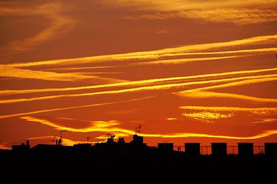 Silhouette cityscape against sky during sunset