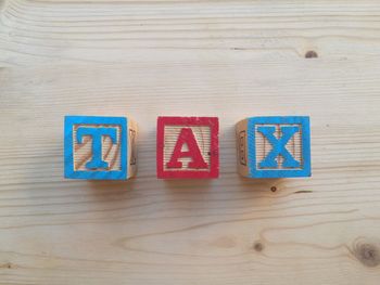 High angle view of tax text made from toy blocks on table