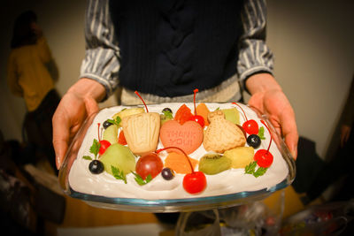 Midsection of woman holding cake