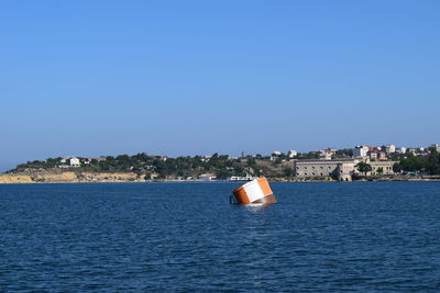 Calm sea against clear blue sky
