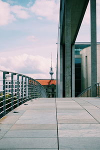 Empty street amidst buildings in city against sky