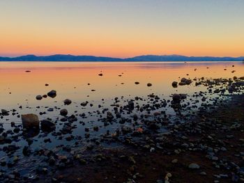 Scenic view of lake against clear sky during sunset