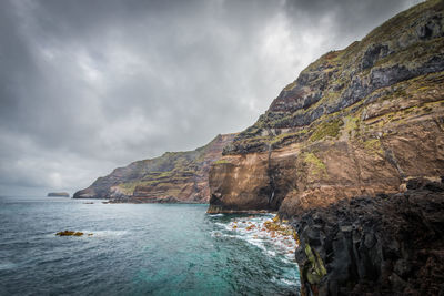 Scenic view of sea and mountains against sky