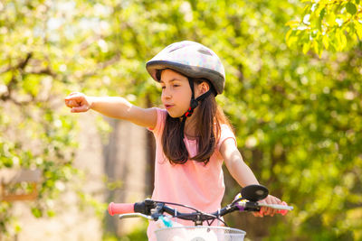 Cute girl riding bicycle outdoors