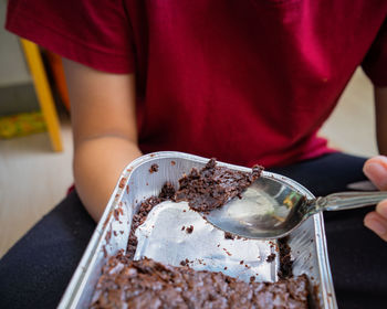 Midsection of man eating cake