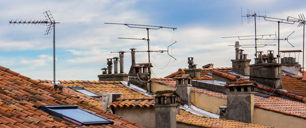 Antennas on roofs against sky