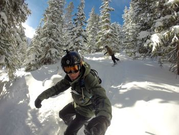 Man holding monopod while skiing in forest