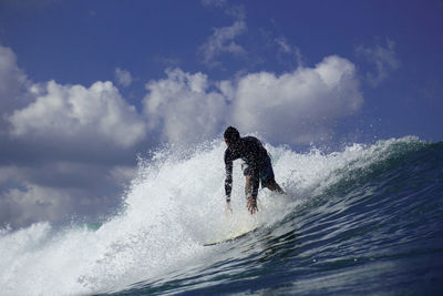 Man surfing in sea against sky