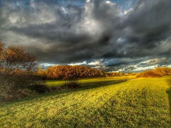 Scenic view of field against dramatic sky
