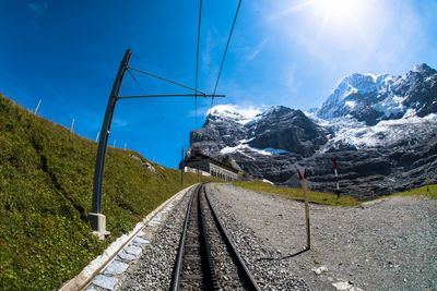 Railroad tracks amidst mountains against sky