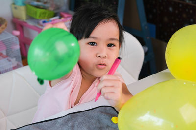 Portrait of young woman with balloons