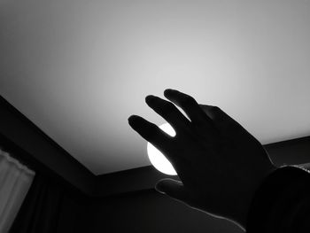 Low angle view of silhouette hand against sky