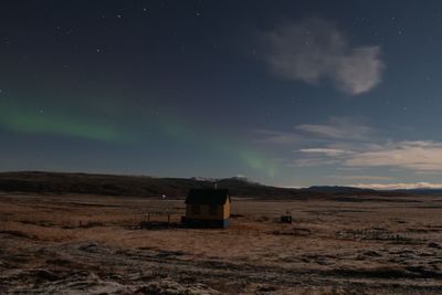 Built structure on field against sky at night