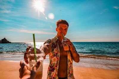 Midsection of man drinking water on beach