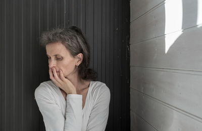 Portrait of woman standing against door