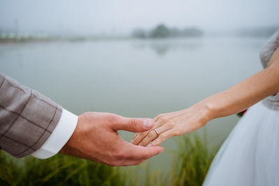 Midsection of couple holding hands