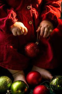 Close-up of baby  holding christmas decoration 