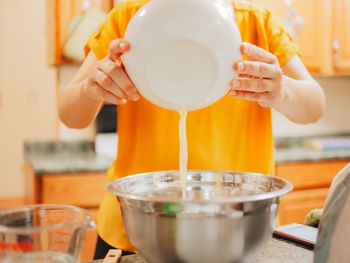 Midsection of woman pouring coffee in cup