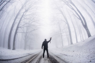 Full length of man on snow covered road during winter