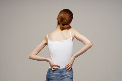 Midsection of woman standing against white background