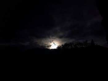 Silhouette landscape against sky at night