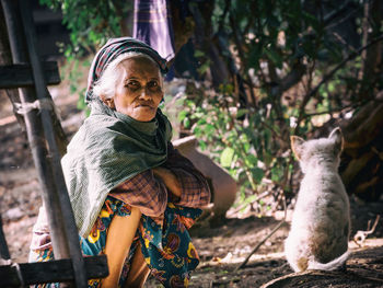 Portrait of woman crouching against outdoors