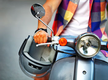 Midsection of man riding motor scooter