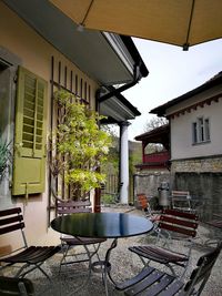 Empty chairs and table outside house in building