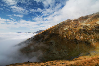 Scenic view of clouds and mountains against sky