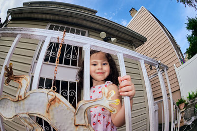 Cute young girl in a summer dress playing in a suburban backyarrd