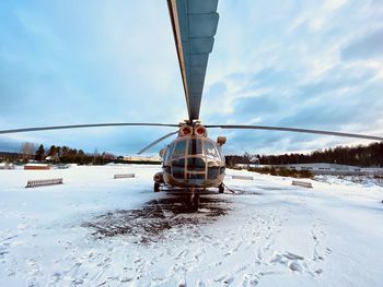 Crane on snow covered land against sky