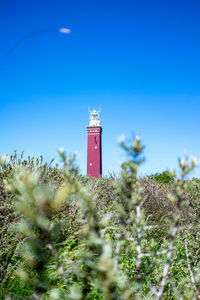 Lighthouse by sea against sky