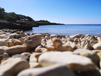 Rocks on beach against clear sky