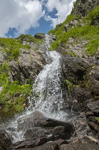 Scenic view of waterfall against sky