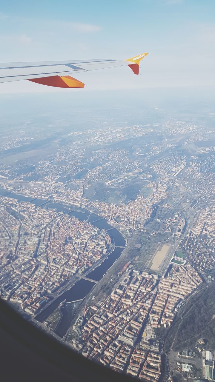 flying, airplane, air vehicle, transportation, mode of transportation, mid-air, aircraft wing, travel, on the move, aerial view, nature, architecture, motion, city, day, sky, cityscape, no people, building exterior, landscape, outdoors