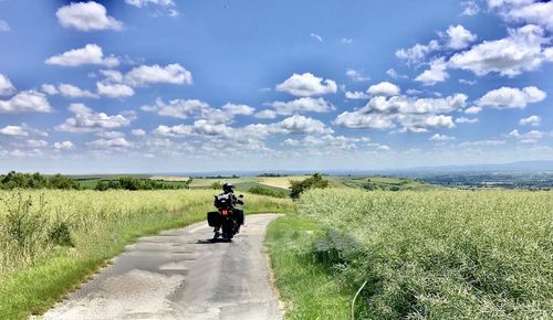 Rear view of people riding motorcycle on road