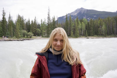 Portrait of young woman standing against athabasca falls