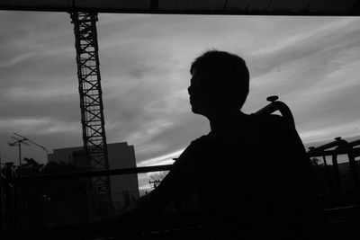 Rear view of silhouette man standing against sky