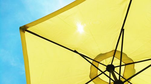 Low angle view of yellow parasol against sky at beach