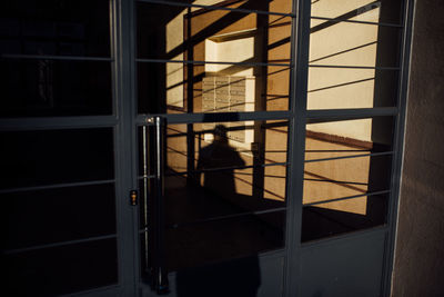 Shadow of man on closed door of house