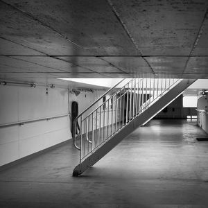 Woman with umbrella walking on floor against wall