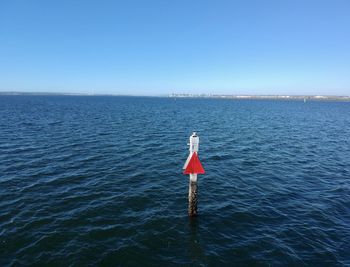 A lone sign post by the ocean