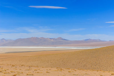 Scenic view of desert against blue sky