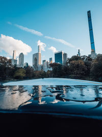 Buildings by swimming pool against blue sky