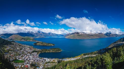 Panoramic view of sea and mountains against blue sky