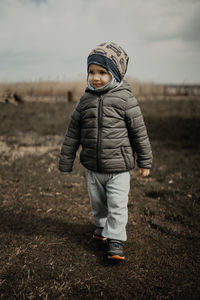 Full length portrait of boy standing on field