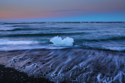 Iceberg on beach at jokulsarlon glacial lagoon