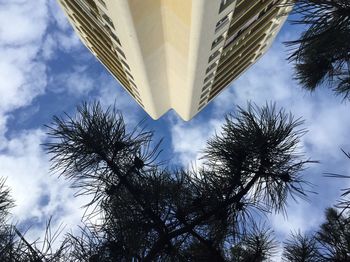 Low angle view of modern building against cloudy sky