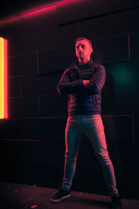 Portrait of young man standing against wall