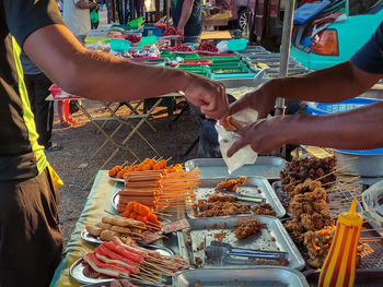 Midsection of man preparing food at market stall